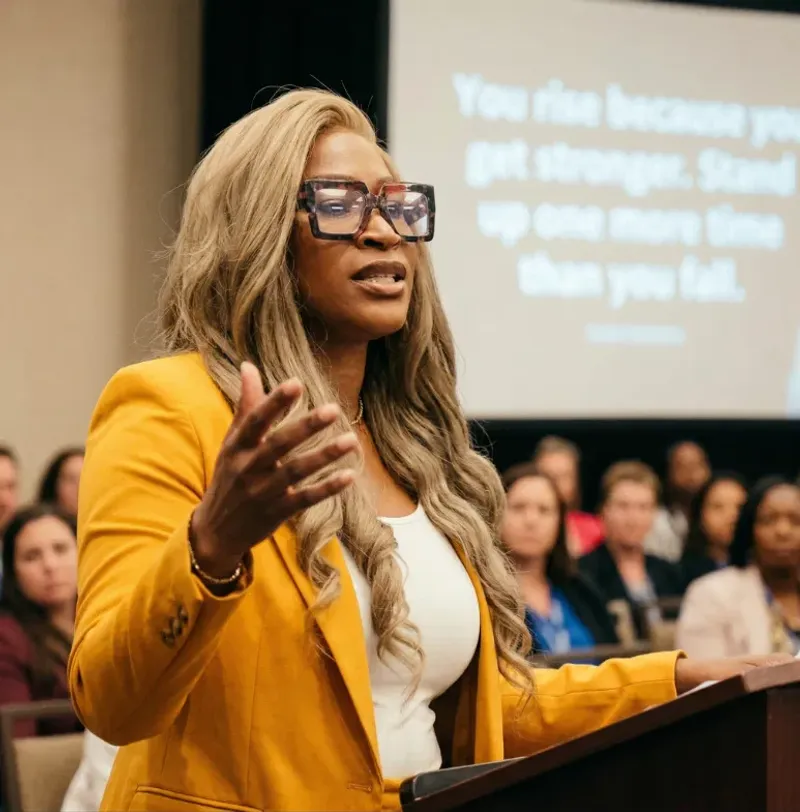 Jande' Freeman-Brewer delivering a keynote at a podium